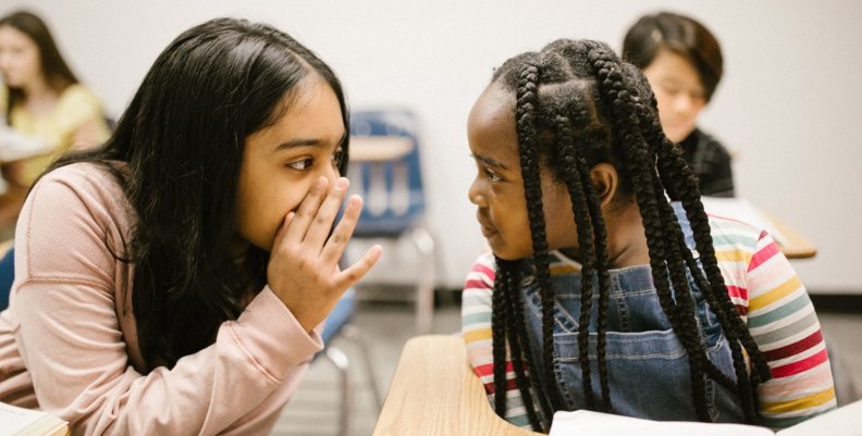 Niñas Dos niñas hablando en un salón de clases
