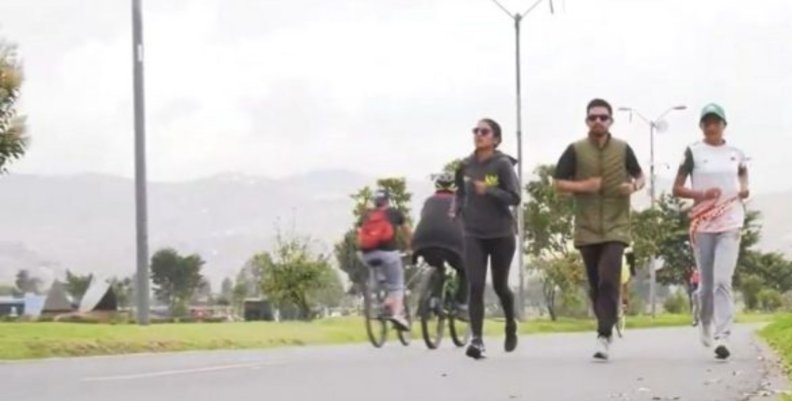 Tres personas trotan al lado de una calle