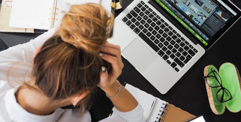Estrés digital Mujer con las manos en la cabeza a raíz del estrés causado por los aparatos electrónicos