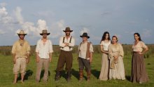 Cuatro hombres y tres mujeres vestidos con ropa antigua del campo