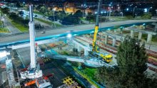 Un puente vehicular de concreto, rodeado de maquinaría de obra