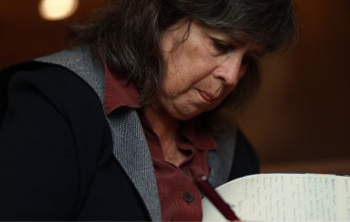 Una mujer de cabello negro firmando un libro